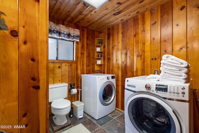 2 Acr 1027, Greer, AZ 85927 - laundry area featuring wooden walls, washing machine and clothes dryer, wooden ceiling, and dark stone finish floors