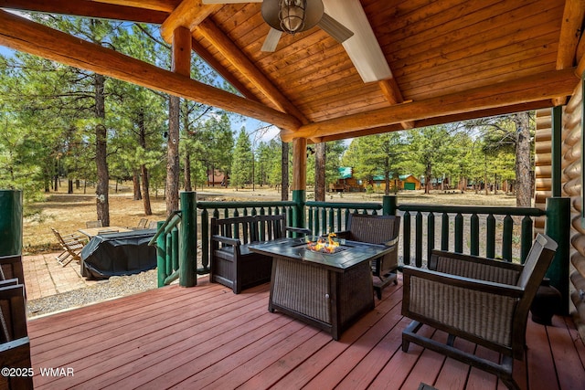 2 Acr 1027, Greer, AZ 85927 - deck featuring view of wooded area, ceiling fan, and an outdoor living space with a fire pit