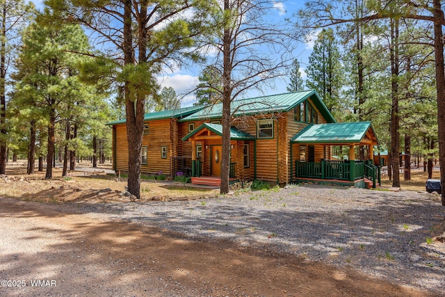 2 Acr 1027, Greer, AZ 85927 - view of front of house with log siding, metal roof, and driveway