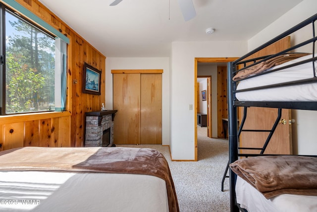 2 Acr 1027, Greer, AZ 85927 - bedroom with carpet, wood walls, a closet, a ceiling fan, and a fireplace