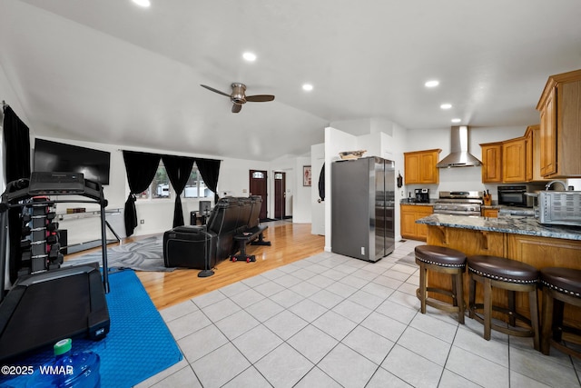 323 N Woodland Rd, Lakeside, AZ 85929 - kitchen featuring appliances with stainless steel finishes, wall chimney range hood, open floor plan, a ceiling fan, and light tile patterned flooring