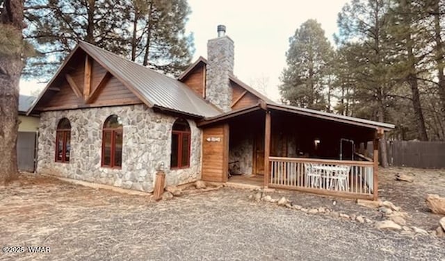 view of front facade with a chimney and metal roof