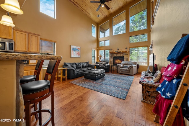 2011 N Lake Breeze Rd, Lakeside, AZ 85929 - living area with high vaulted ceiling, light wood-style flooring, plenty of natural light, a ceiling fan, and a stone fireplace