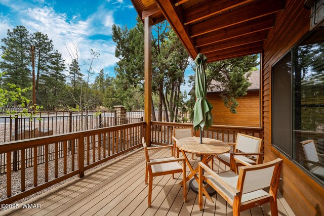 2011 N Lake Breeze Rd, Lakeside, AZ 85929 - wooden deck with fence, outdoor dining space, and view of wooded area