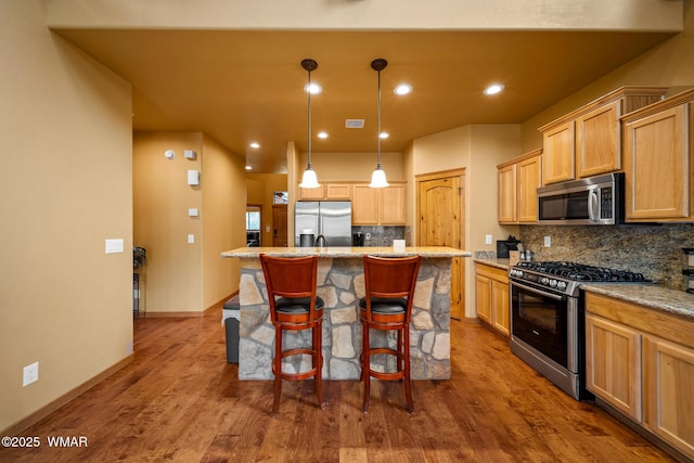 2011 N Lake Breeze Rd, Lakeside, AZ 85929 - kitchen with stainless steel appliances, tasteful backsplash, a breakfast bar area, a center island, and dark wood finished floors