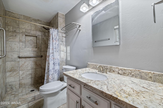 full bathroom with toilet, a stall shower, a textured wall, and vanity