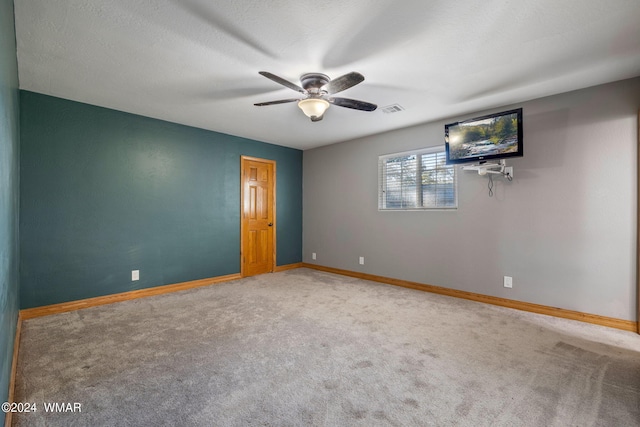 carpeted empty room featuring baseboards, visible vents, and ceiling fan