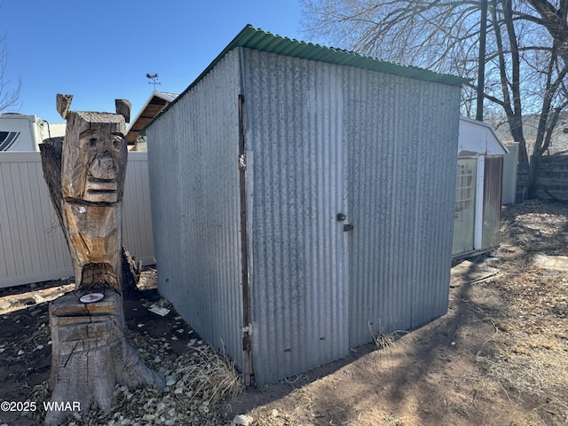 view of shed featuring fence