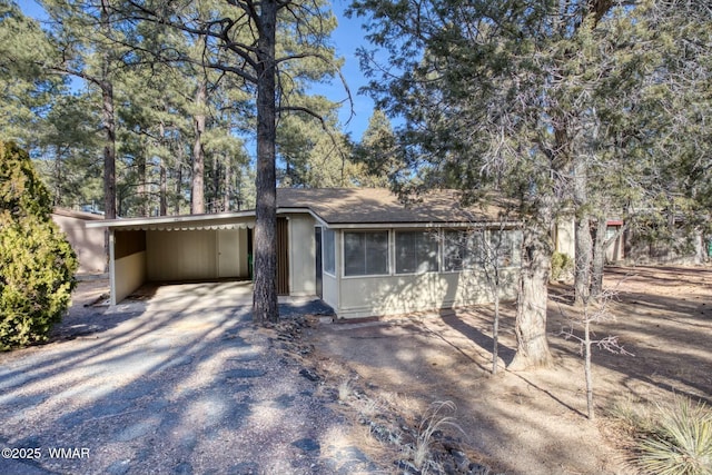 view of front of house featuring an attached carport and gravel driveway