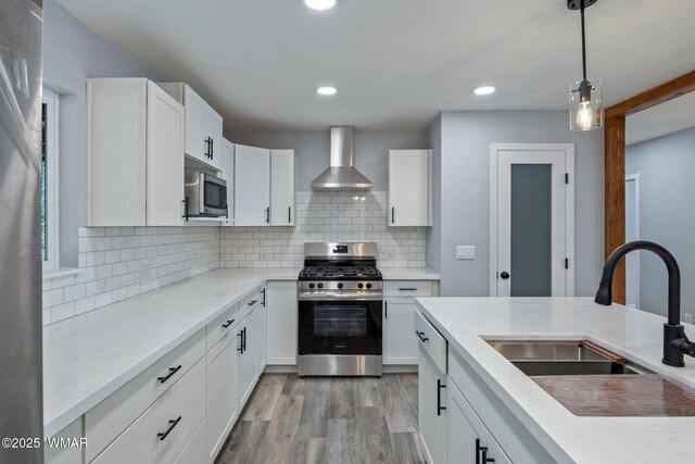 261 S 5th Pl, Show Low, AZ 85901 - kitchen featuring stainless steel appliances, wall chimney range hood, light wood-style flooring, white cabinets, and recessed lighting