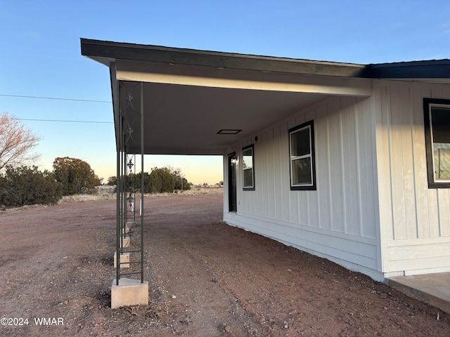 property exterior at dusk featuring an attached carport