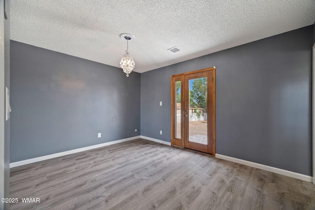 236 E 6th St, Eagar, AZ 85925 - spare room with wood finished floors, a chandelier, and a textured ceiling