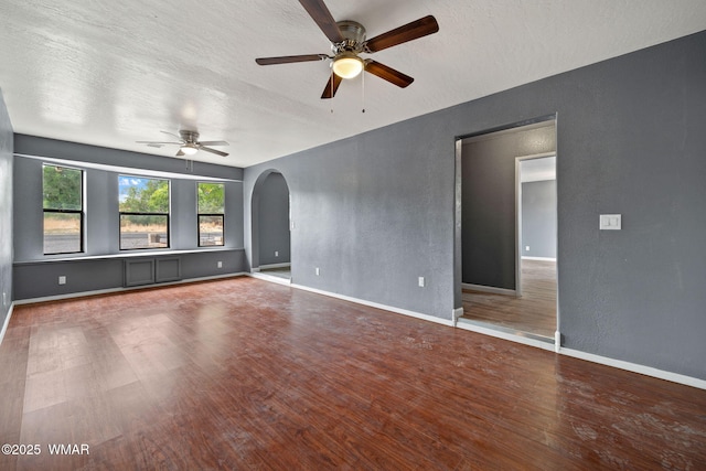236 E 6th St, Eagar, AZ 85925 - unfurnished room with a ceiling fan, wood finished floors, arched walkways, a textured ceiling, and a textured wall