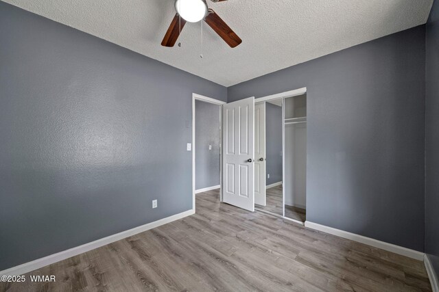 236 E 6th St, Eagar, AZ 85925 - unfurnished bedroom featuring wood finished floors, a textured ceiling, a closet, and ceiling fan