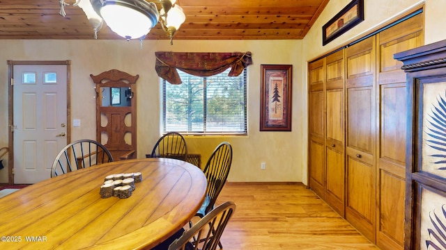 dining room featuring lofted ceiling, wooden ceiling, and light wood finished floors