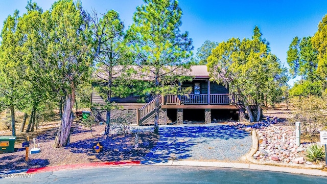 rear view of property featuring a wooden deck and stairs