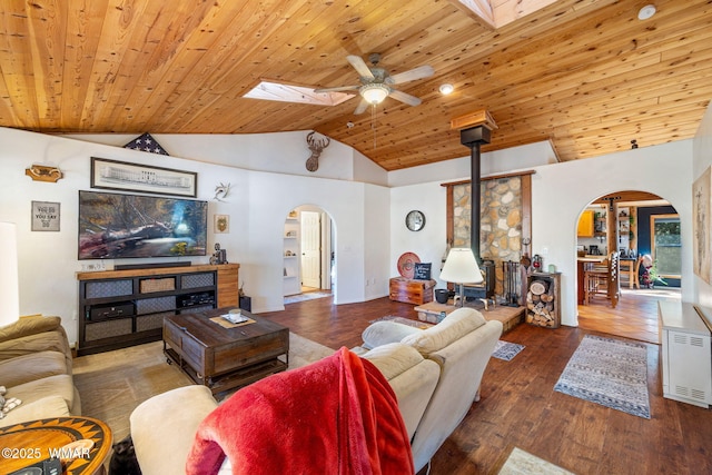 4584 Cub Lake Rd, Show Low, AZ 85901 - living area featuring arched walkways, a wood stove, ceiling fan, vaulted ceiling, and wooden ceiling