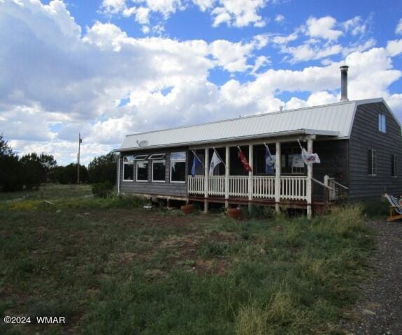 farmhouse with metal roof, a porch, and a gambrel roof