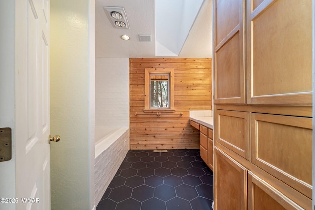 1825 E Woodchuck Ln, Pinetop, AZ 85935 - bathroom featuring wood walls, a washtub, visible vents, and tile patterned flooring