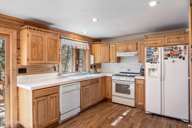1825 E Woodchuck Ln, Pinetop, AZ 85935 - kitchen with light wood finished floors, tasteful backsplash, a sink, white appliances, and under cabinet range hood