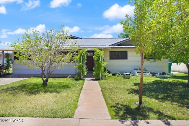 view of front facade with metal roof and a front lawn