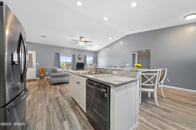 289 N Divot Dr, Eagar, AZ 85925 - kitchen with stainless steel appliances, open floor plan, lofted ceiling, light wood-style flooring, and white cabinetry