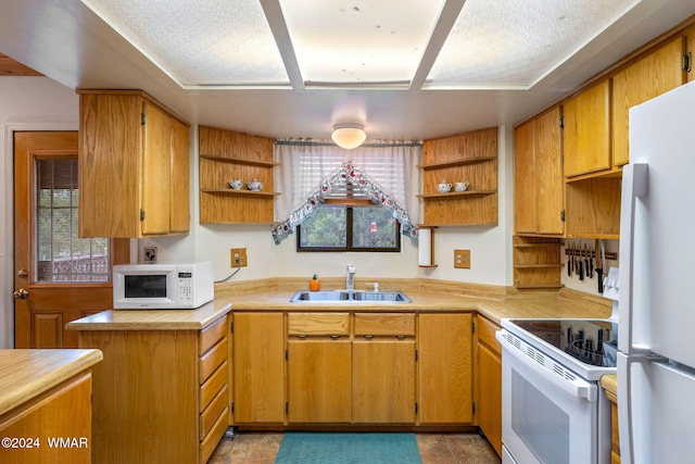 kitchen featuring white appliances, light countertops, a sink, and open shelves