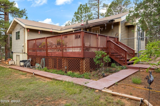 rear view of house with a lawn and a wooden deck