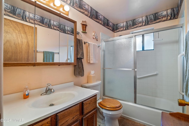 bathroom featuring toilet, shower / bath combination with glass door, tile patterned floors, and vanity