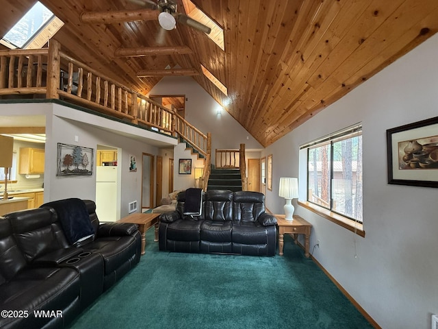 carpeted living area featuring a skylight, stairs, wood ceiling, visible vents, and high vaulted ceiling