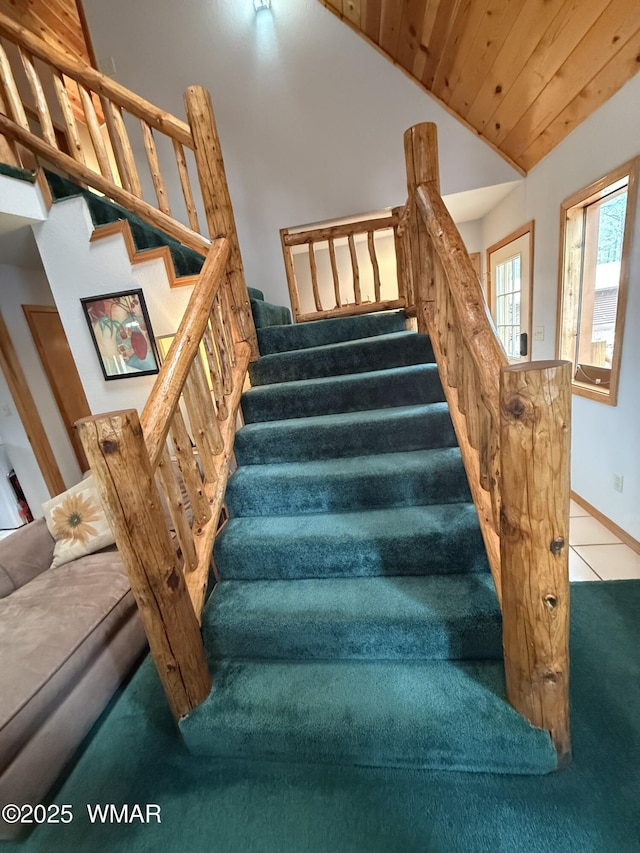 staircase featuring carpet flooring, lofted ceiling, and baseboards