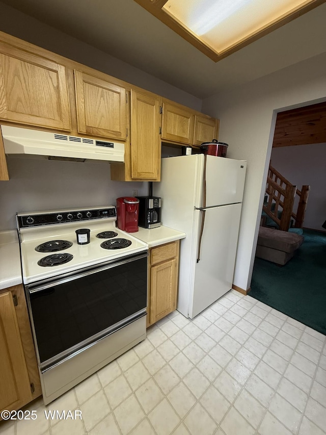 kitchen with white appliances, under cabinet range hood, and light countertops