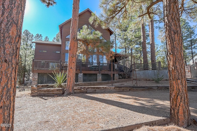 rear view of property featuring a wooden deck