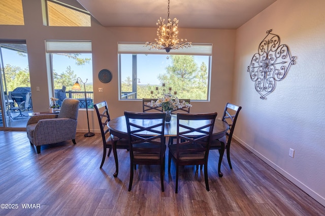 dining space with baseboards, dark wood finished floors, and an inviting chandelier