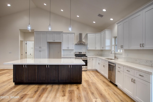 1028 School House Ln, Show Low, AZ 85901 - kitchen with appliances with stainless steel finishes, high vaulted ceiling, wall chimney exhaust hood, a kitchen island, and light wood-type flooring