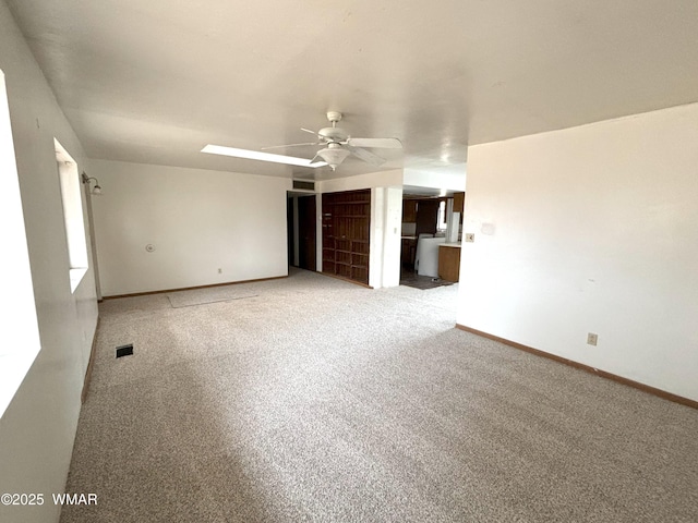 interior space featuring a ceiling fan, baseboards, visible vents, and carpet flooring