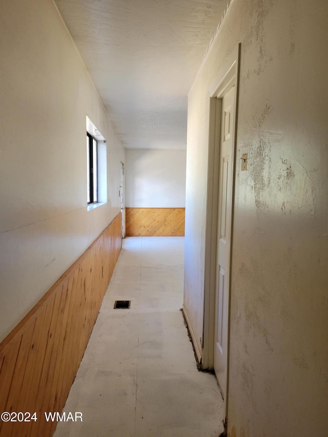 hall featuring a wainscoted wall and visible vents