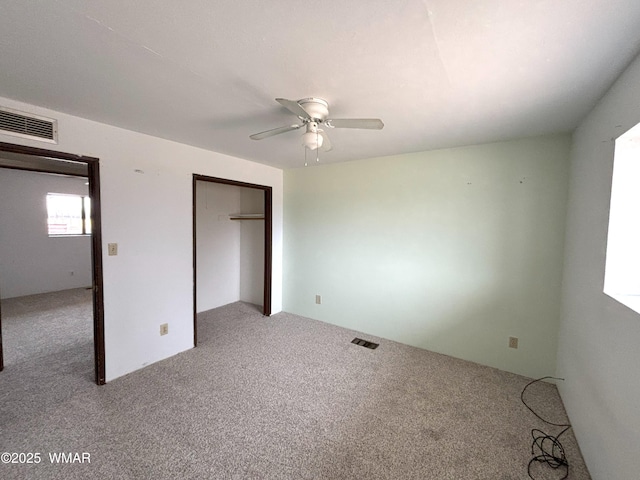 unfurnished bedroom with carpet floors, a closet, and visible vents