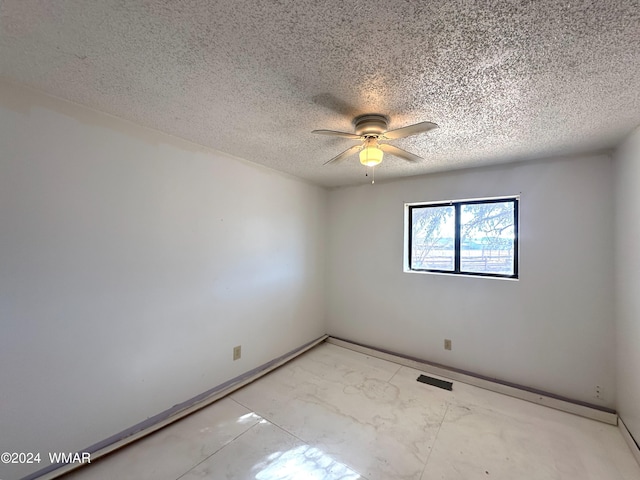 unfurnished room featuring a ceiling fan, baseboards, visible vents, and a textured ceiling