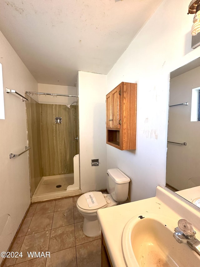 full bath featuring toilet, a shower stall, vanity, and tile patterned floors