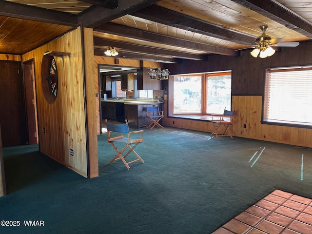 kitchen with beamed ceiling, wood walls, dark colored carpet, and wood ceiling