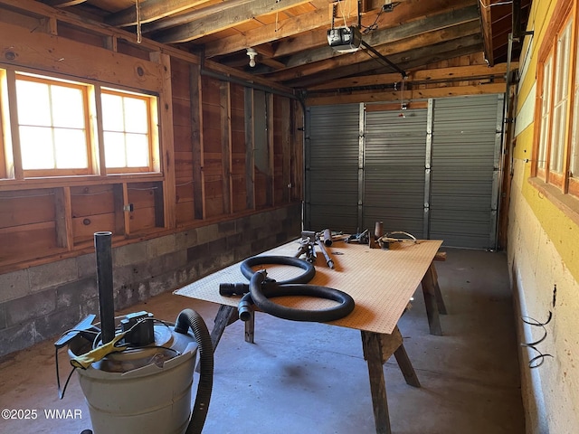 garage with concrete block wall and a garage door opener