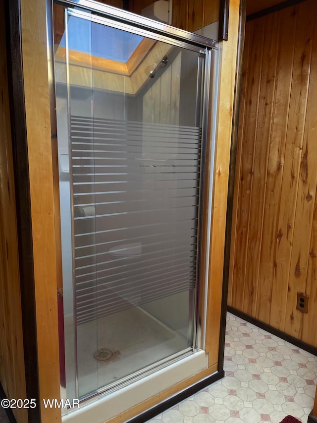 interior space with a stall shower, wooden walls, and tile patterned floors