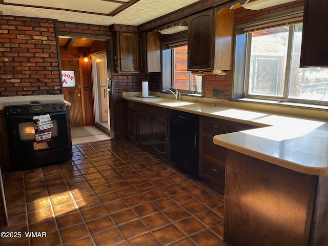 kitchen featuring black appliances, dark brown cabinets, a sink, and light countertops