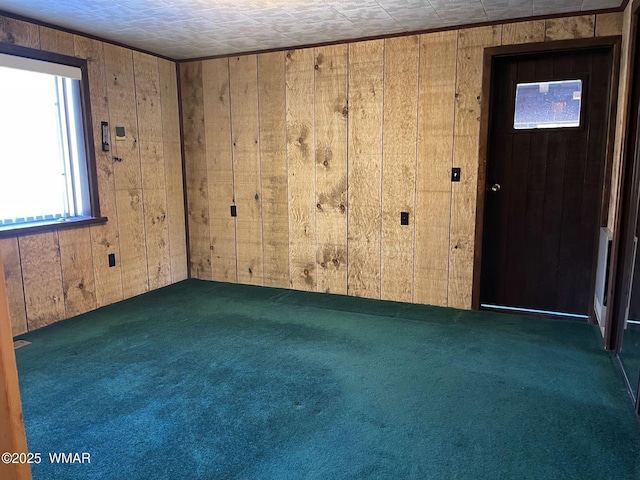 empty room featuring dark colored carpet and wooden walls