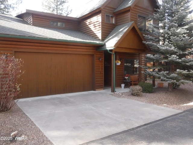 3024 Buck Crossing Way, Pinetop, AZ 85935 - view of front facade with roof with shingles, an attached garage, concrete driveway, and log veneer siding