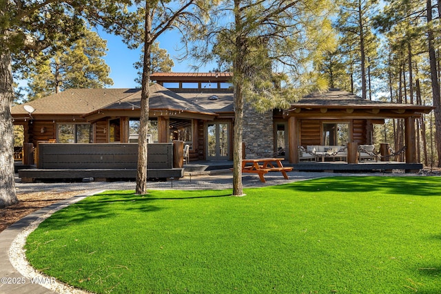 back of property with log siding, an outdoor living space, a patio, and a yard