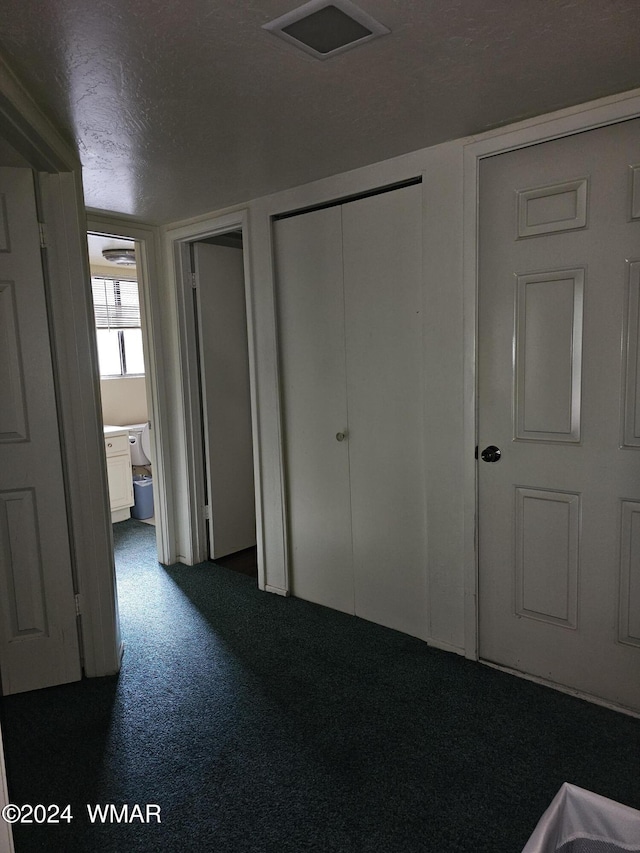 2844 Park Cir Unit 36A, Pinetop, AZ 85935 - unfurnished bedroom featuring a textured ceiling, dark colored carpet, two closets, and visible vents
