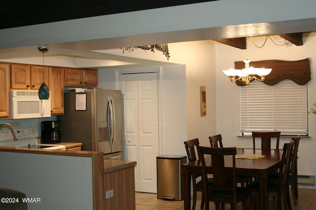 kitchen featuring white appliances, light tile patterned floors, brown cabinetry, pendant lighting, and a notable chandelier