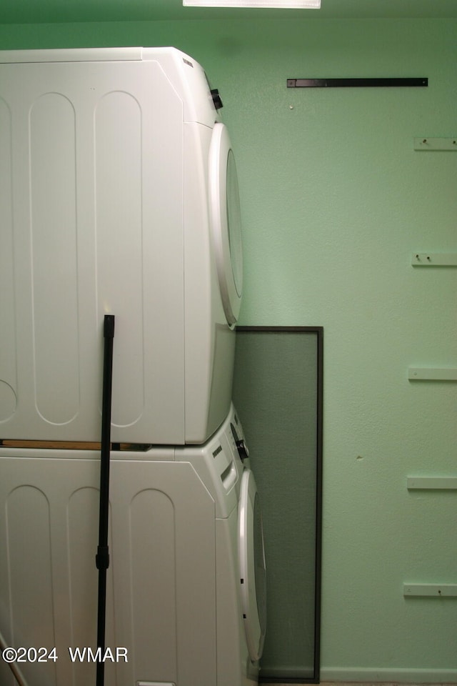 clothes washing area featuring laundry area and stacked washer and clothes dryer